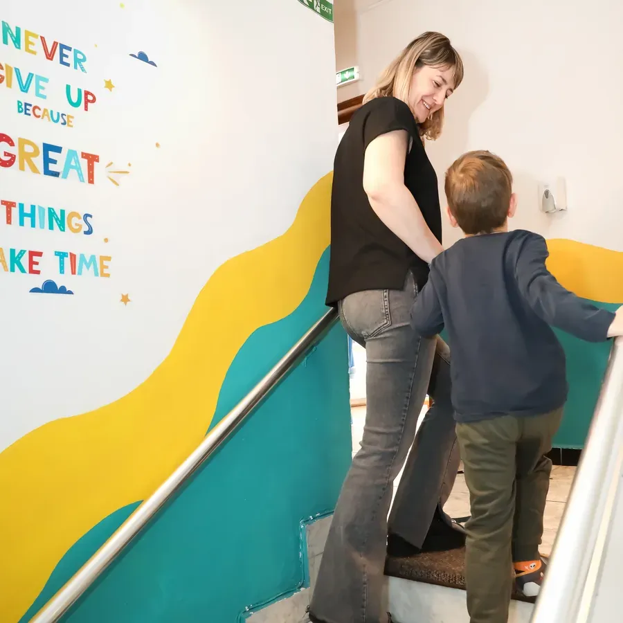Educatoare urcând scările alături de un copil